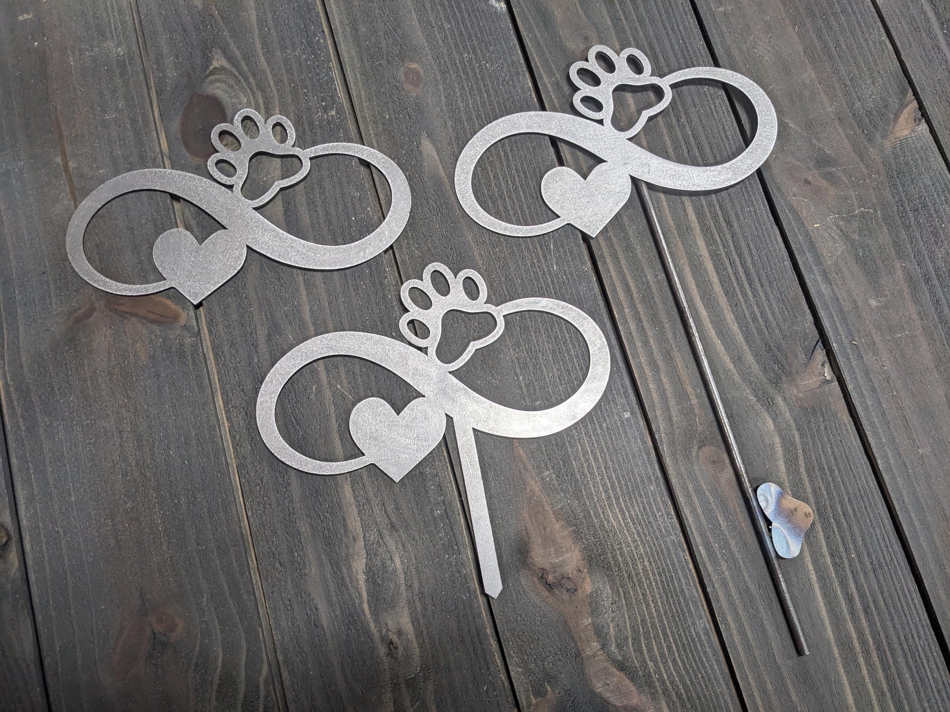 Examples of the variations of the Infiniti dog paw garden stake. options include the Infiniti dog paw metal sign without a stake, with a short stake, and with a longer welded stake. personalization options are also available.