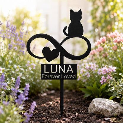 May include: A black metal garden stake featuring a silhouette of a cat sitting atop an infinity symbol with a heart shape. Below the infinity symbol is a rectangular plaque with the text LUNA and the words Forever Loved printed in white.