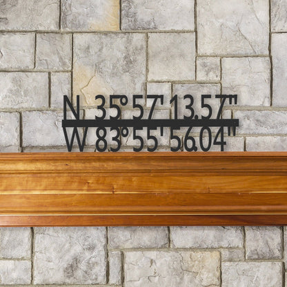 Photo showing a custom GPS coordinate metal sign above a fireplace mantel. the sign shows unique or memorable location coordinates. the metal sign is finished in a hammered black paint and can be used indoors or outdoors.