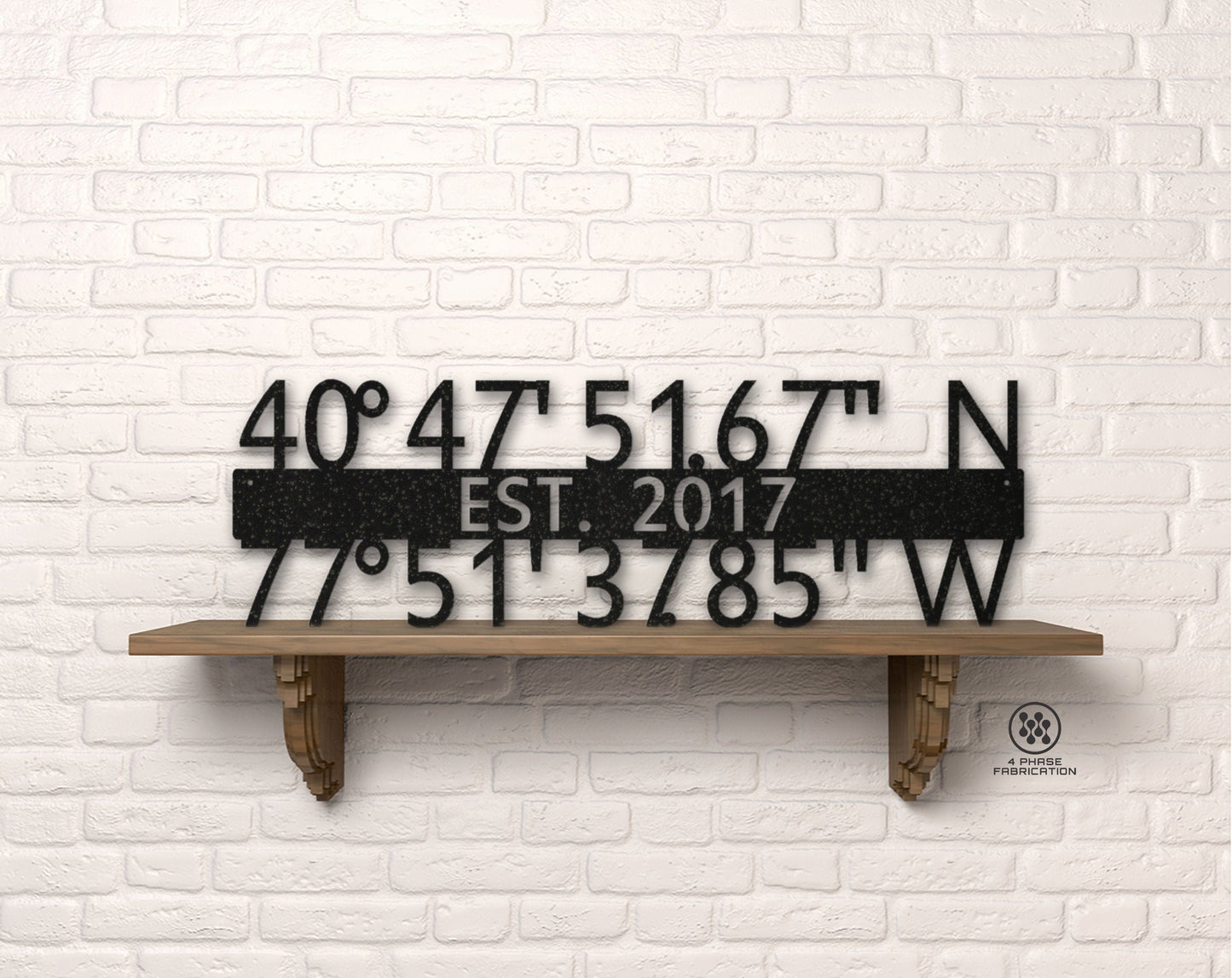May include: Black metal sign with coordinates 40°47'51.67" N and 77°51'3785" W, EST. 2017. The sign is displayed on a wooden shelf against a white brick wall. The sign is a decorative item.